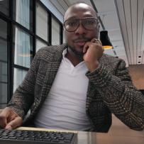 Emile Johnson sits facing the camera with his hand on his chin