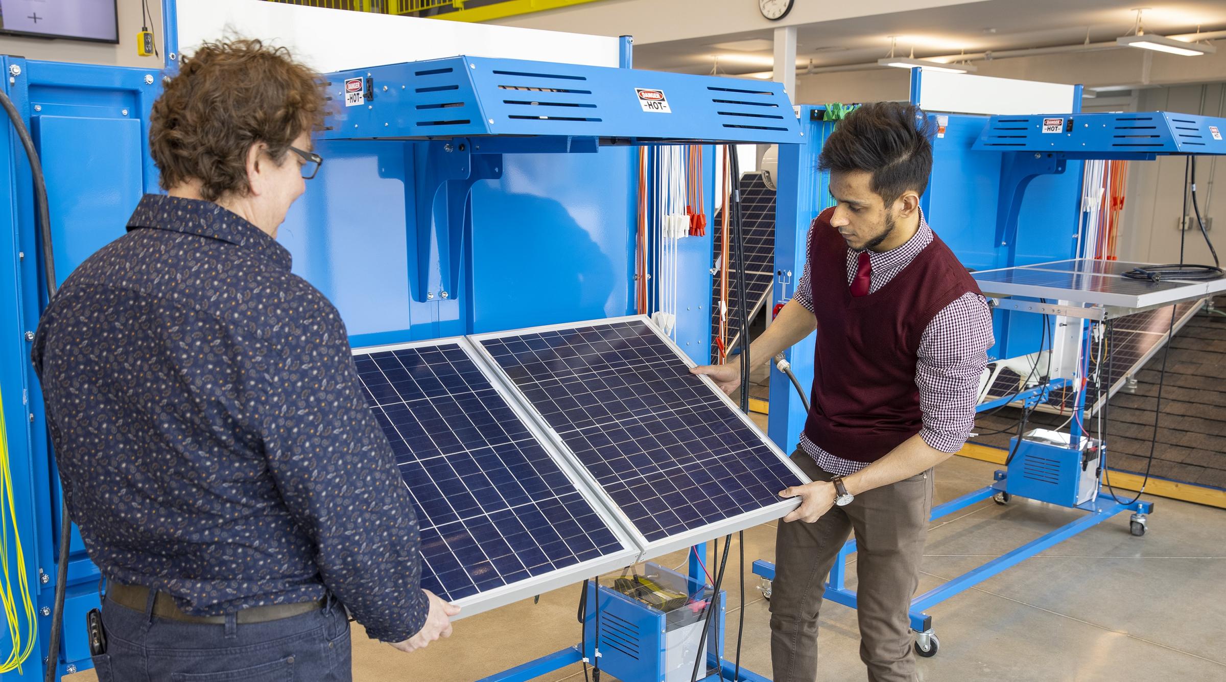 Instructor and student examining solar panel