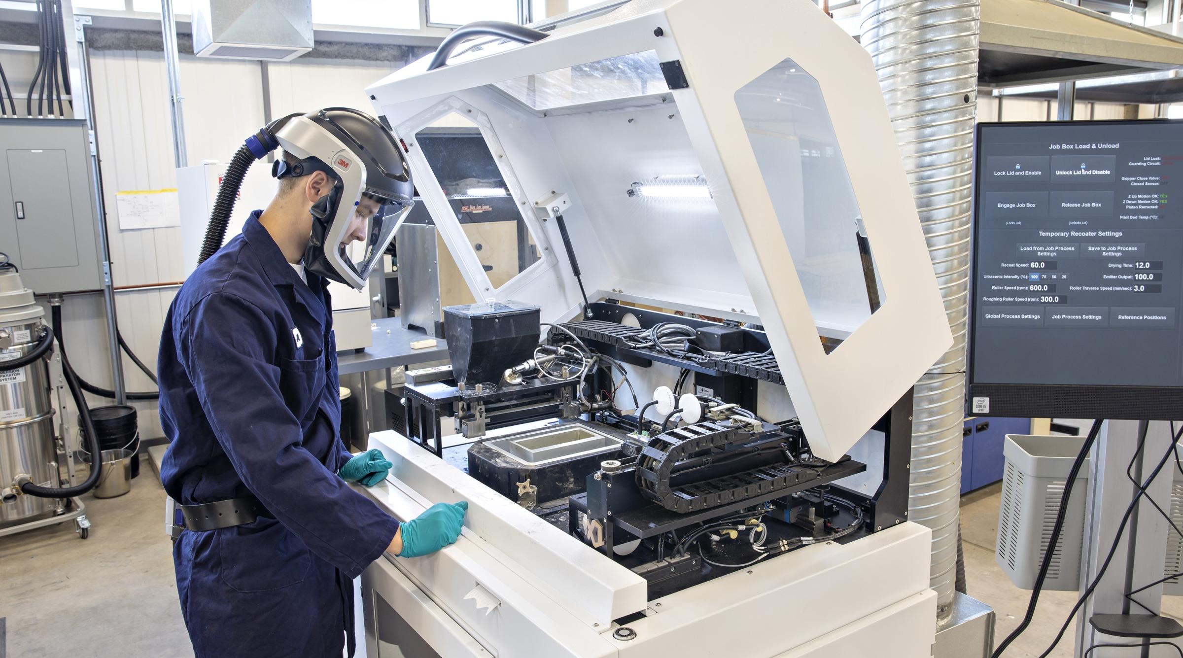Student working at a printer in the CIM-TAC