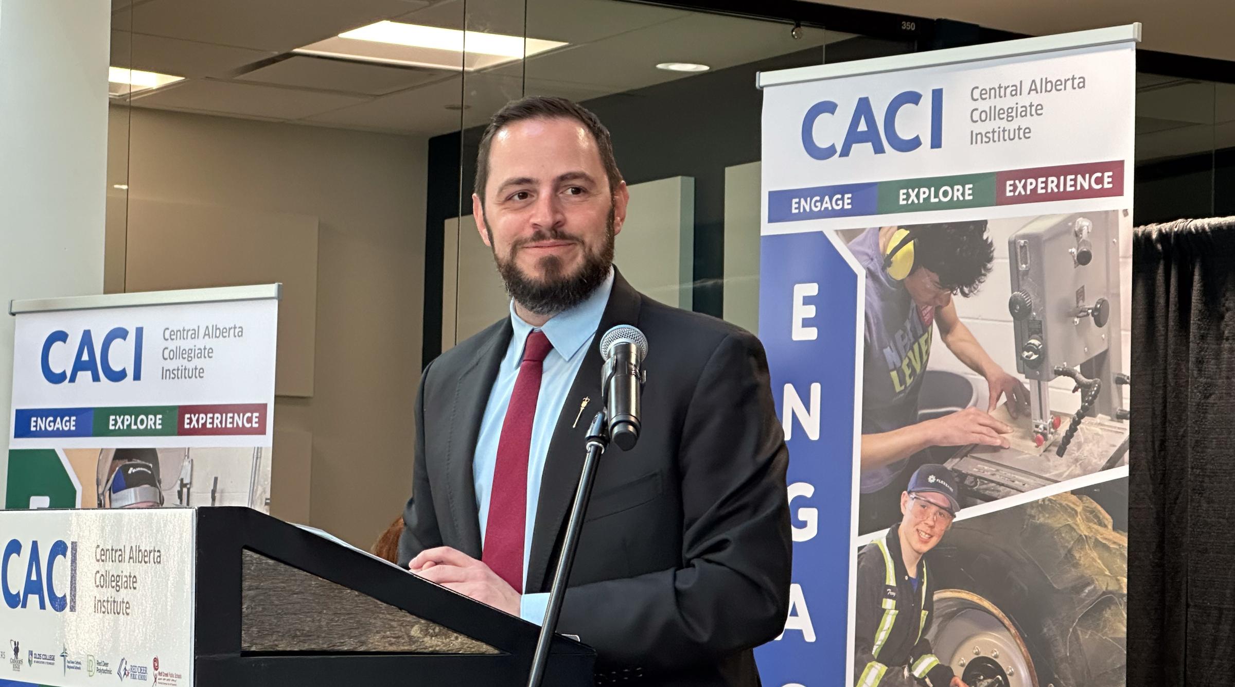 The Honourable Demitrios Nicolaides, Alberta's Minister of Education, speaks at podium