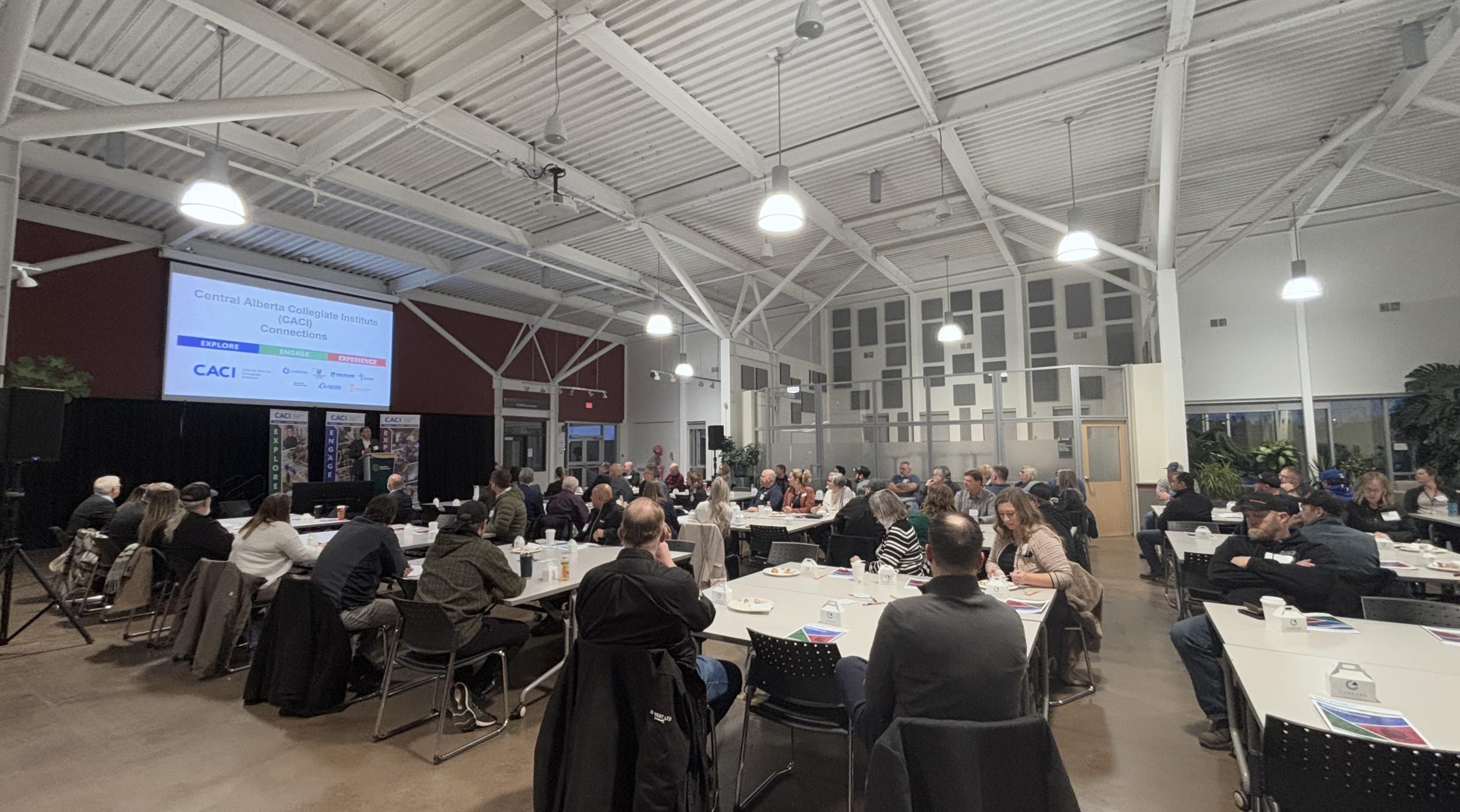 A large crowd listens to a speaker at the CACI event at RDP
