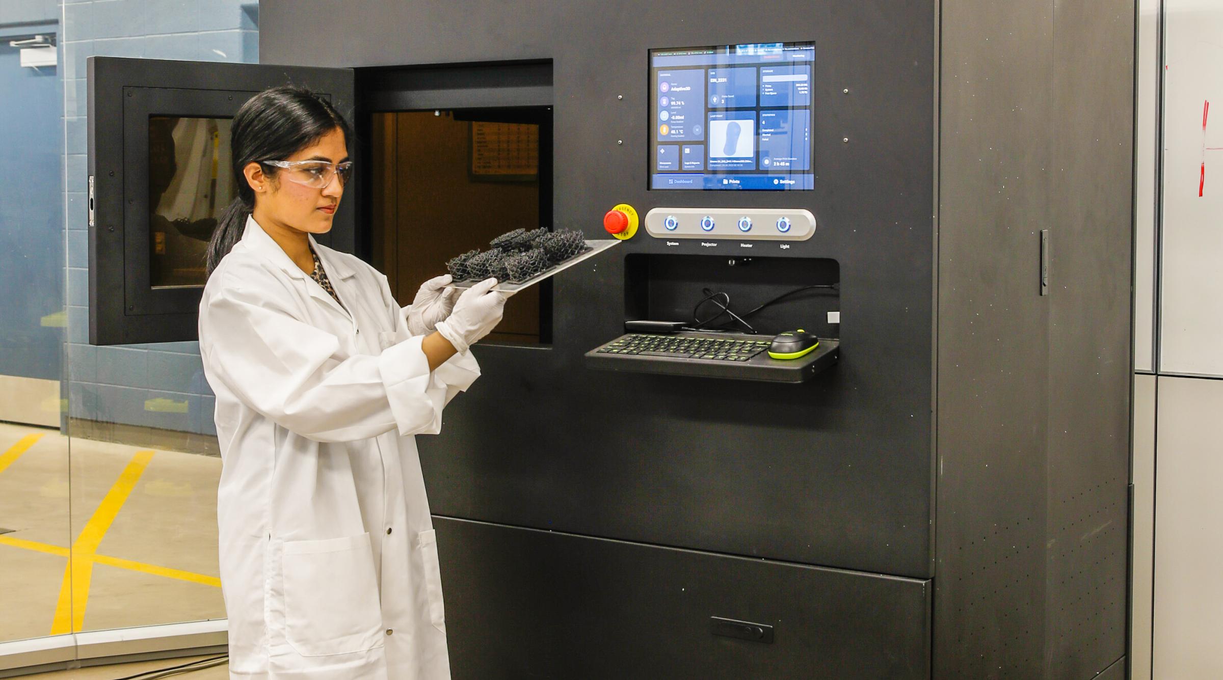 Research technician using 3d printer.