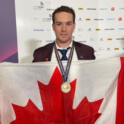 Ben Rainforth holds a Canadian flag while wearing his bronze medal from the WorldSkills Competition