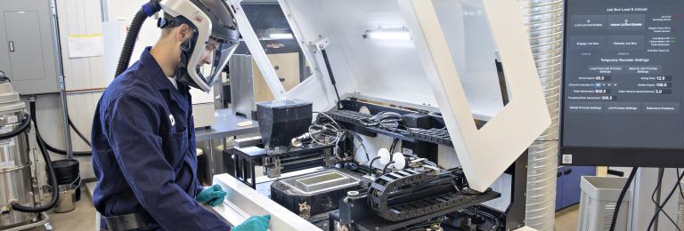 Student working at a printer in the CIM-TAC