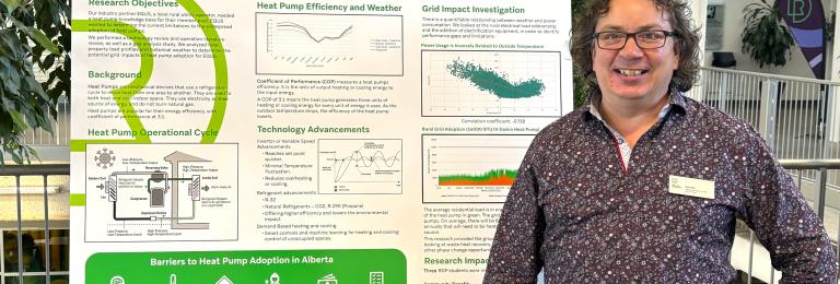 A researcher in a purple shirt stands with a hand on their hip, next to a presentation board that reads "heat pump performance in alberta"