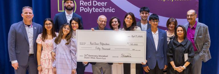A group shot of smiling members of the ZS Holdings group with RDP President. The group holds a cheque for $50,000