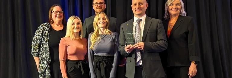 Dan Haas receiving the Community Inclusion Award on stage with a few other group members