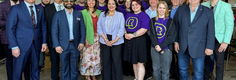 Rajan Sawhney stands in front of a group of RDP staff and students.