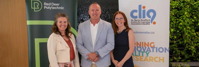 Dr. Tonya WOlfe, Tony Weeks, and Catherine Laing stand smiling in front of RDP and CLIQ banners
