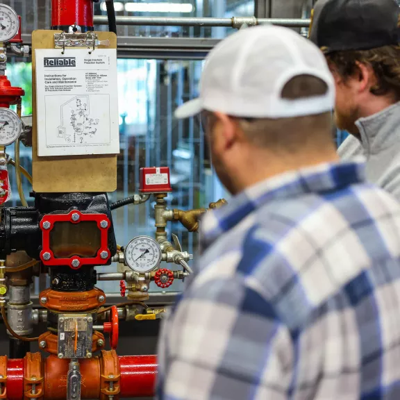 Two students inspecting sprinkler system