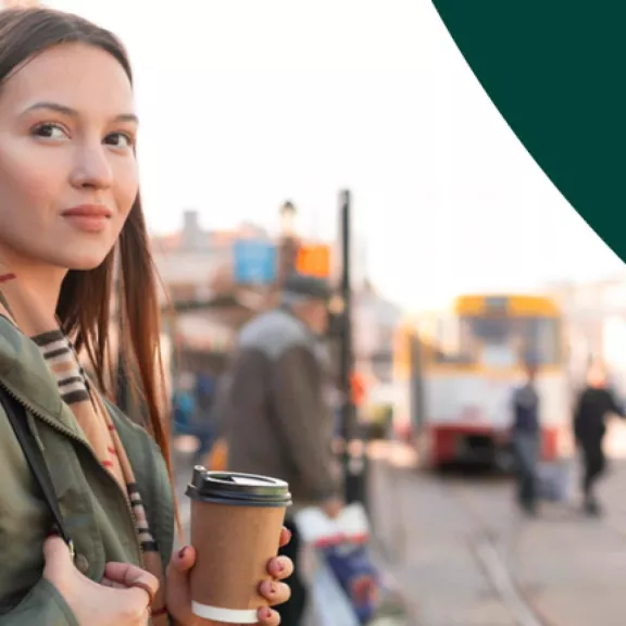 Female holding coffee in a new country