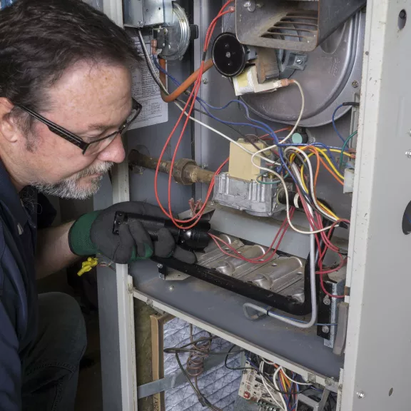 Technician fixing a furnace.
