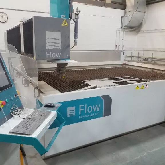 A wide shot of the waterjet cutter. A large industrial-looking machine