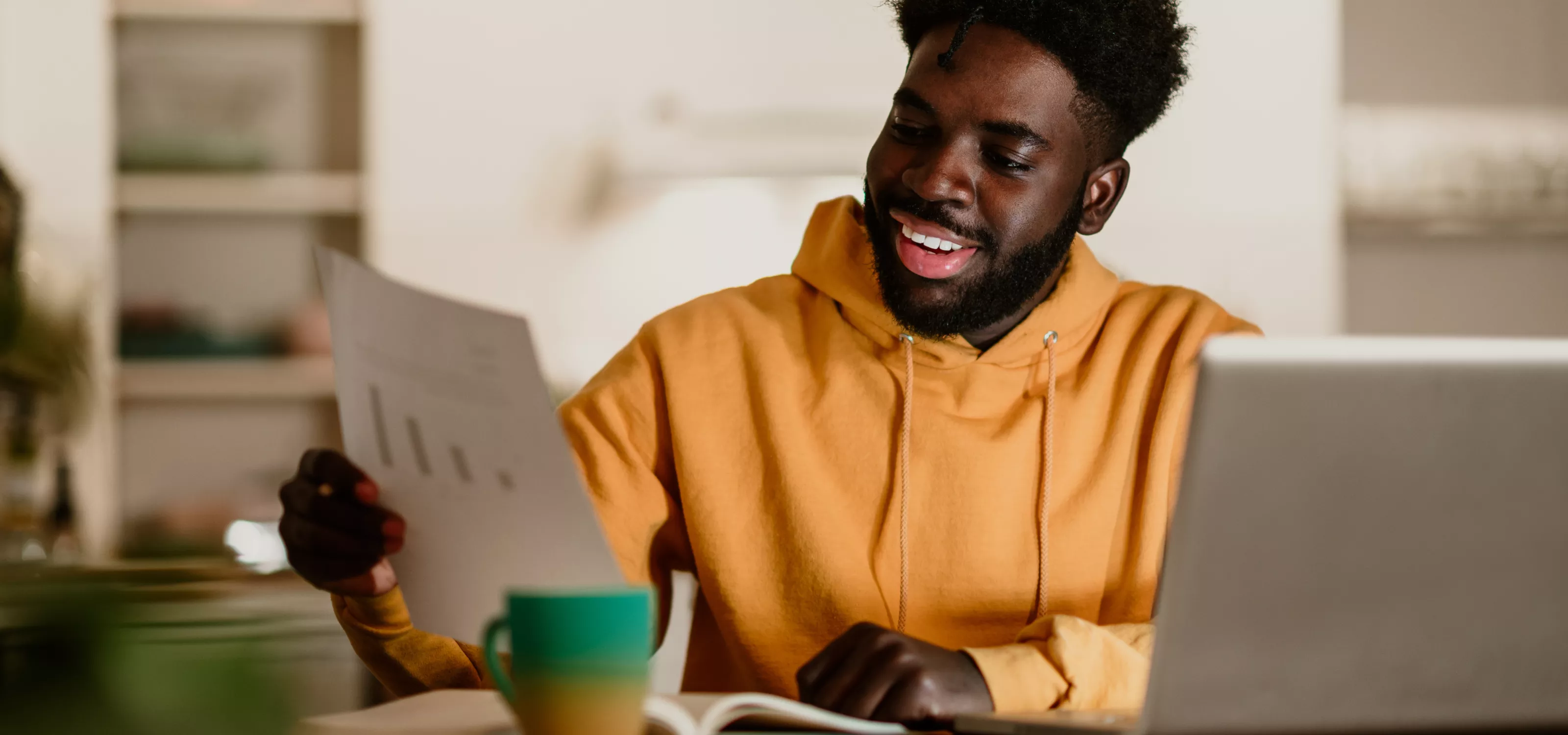 Young man looking at a bar graph smiling.