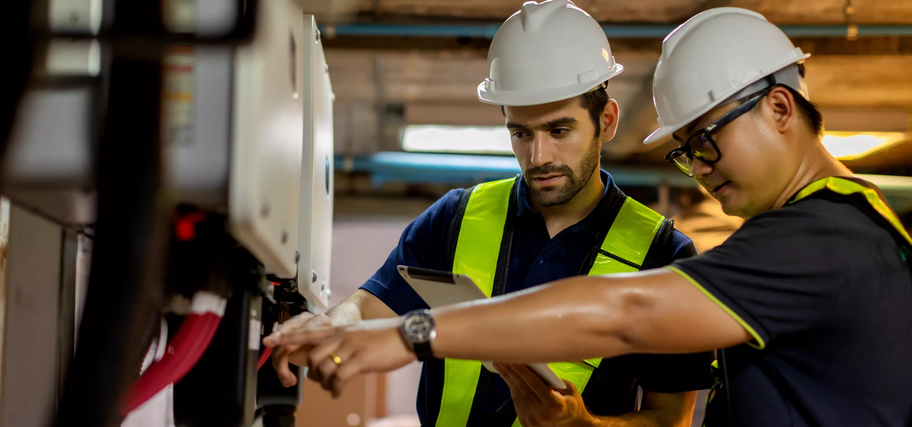 Two electrical power engineers looking at a panel.