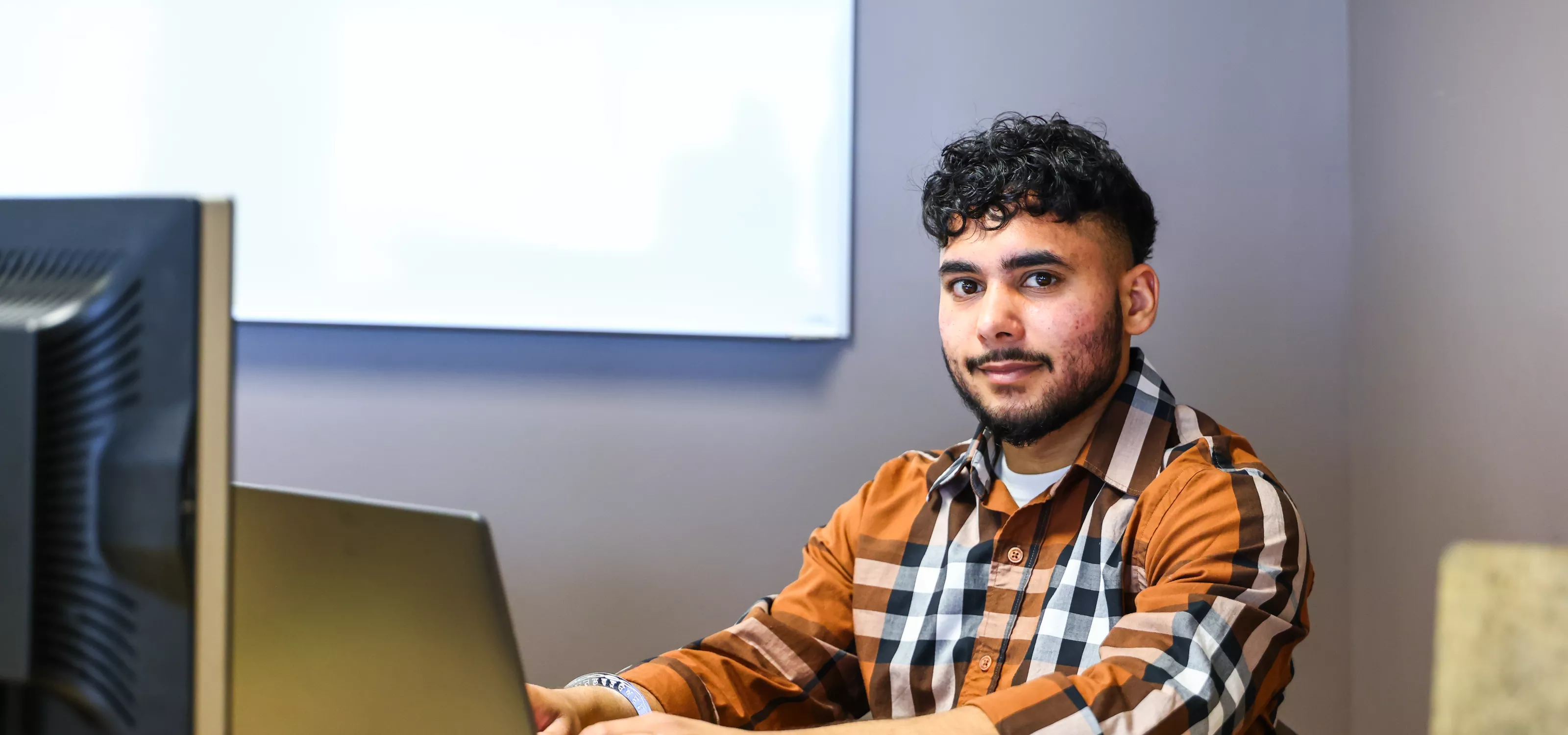 Student with a laptop looking at the camera.